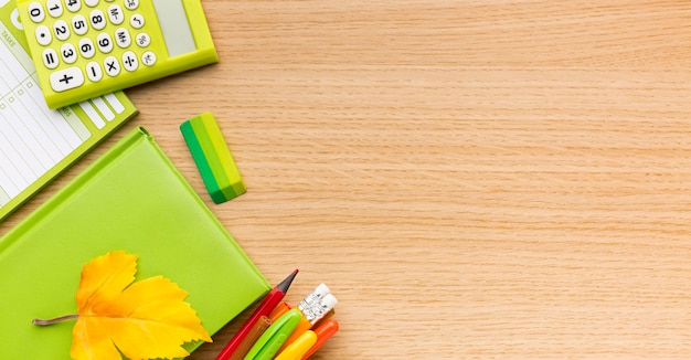 Vista dall'alto di ritorno a materiale scolastico con copia spazio e libro