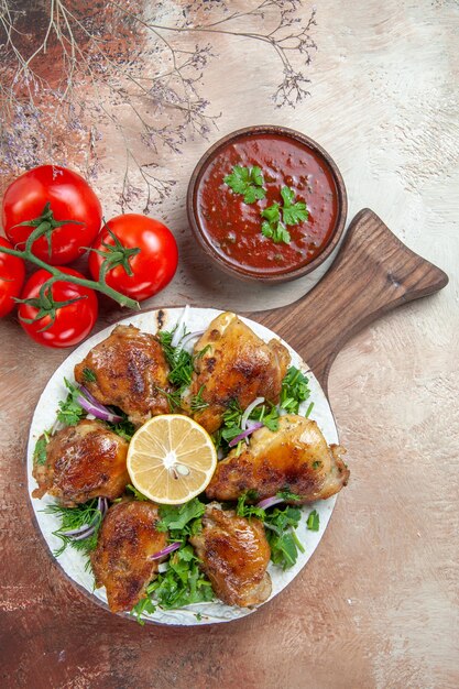 Vista dall'alto di salsa di pollo pomodori con pedicels pollo con erbe aromatiche al limone sul tabellone