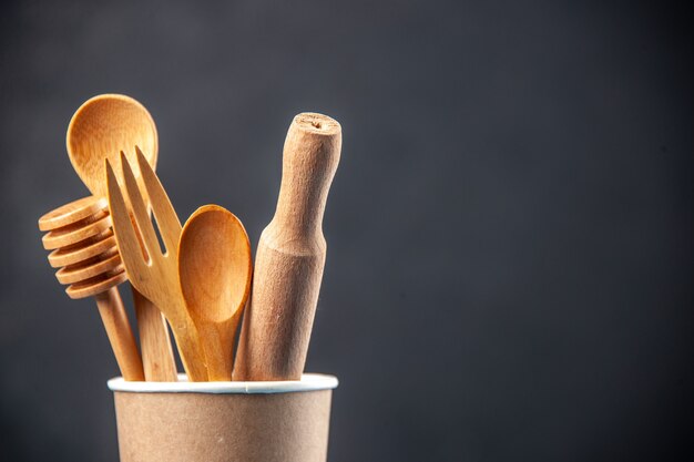 Vista dall'alto di sapoons di legno in una caffettiera di plastica vuota su una superficie scura