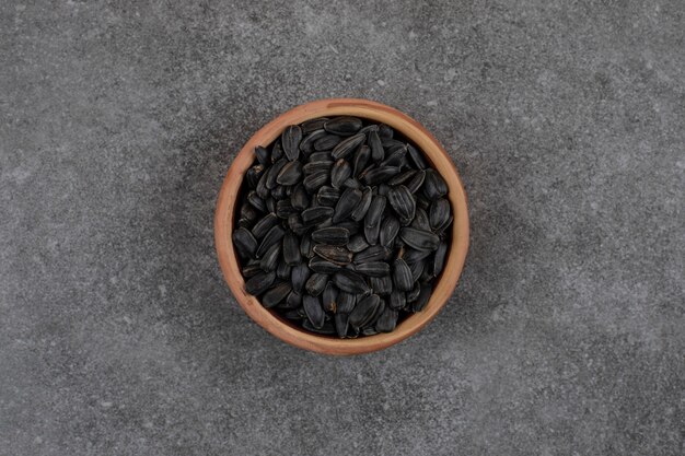 Vista dall'alto di semi di girasole neri su superficie grigia
