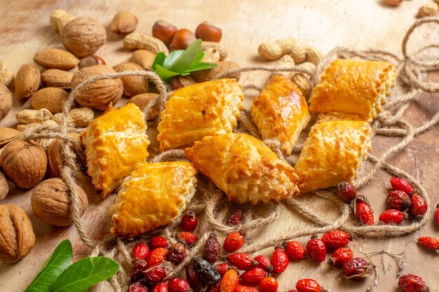 Vista dall'alto di squisiti pasticcini di noci con noci fresche sulla scrivania marrone