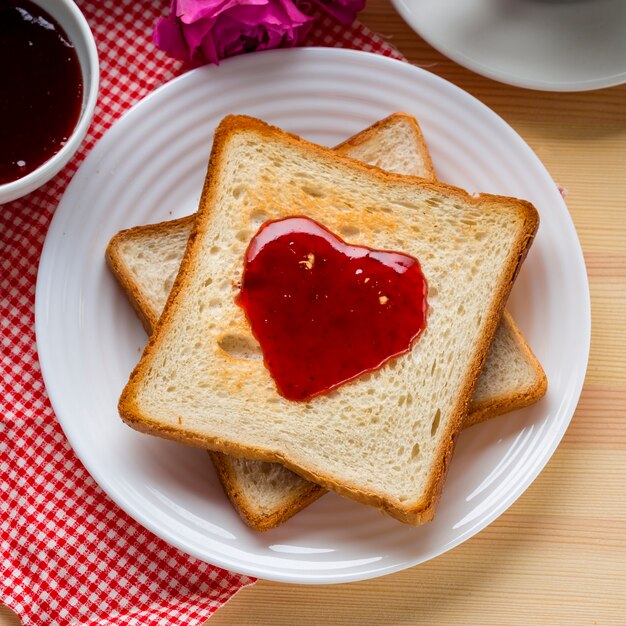 Vista dall'alto di toast con marmellata e rosa