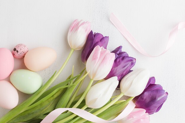 Vista dall'alto di tulipani con colorate uova di Pasqua