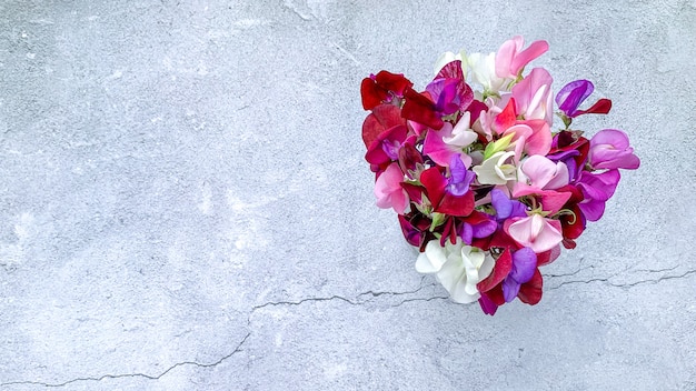 Vista dall'alto di un bellissimo bouquet di fiori di pisello dolce colorato su una superficie grunge