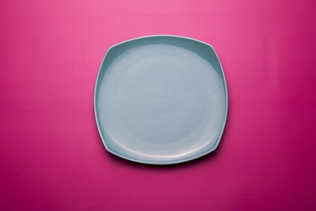 Vista dall'alto di un piatto in ceramica isolato su una superficie rosa brillante
