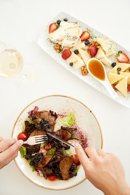 Vista dall'alto di un piede flatlay, deliziosa insalata e set di formaggi