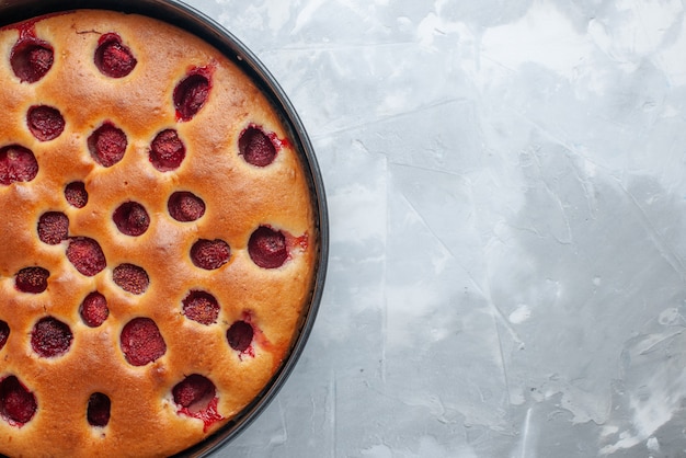 Vista dall'alto di una deliziosa torta di fragole al forno con fragole rosse fresche all'interno con padella sulla scrivania leggera, torta biscotti frutta dolce cuocere