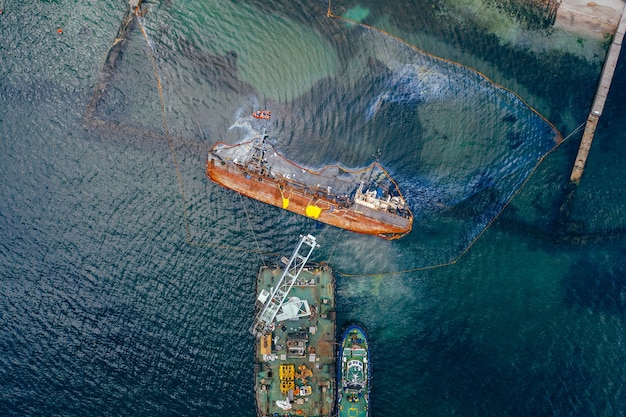 Vista dall'alto di una vecchia petroliera che si è arenata e si è ribaltata sulla riva vicino alla costa.