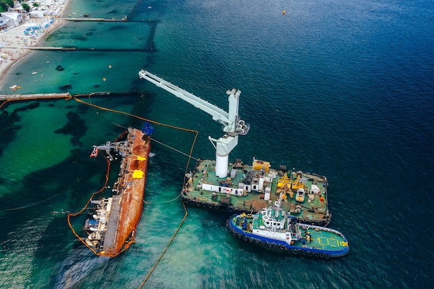 Vista dall'alto di una vecchia petroliera incagliata e ribaltata sulla riva vicino alla costa