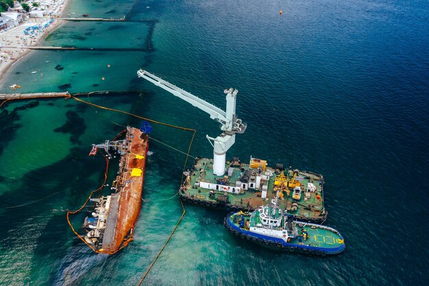 Vista dall'alto di una vecchia petroliera incagliata e ribaltata sulla riva vicino alla costa