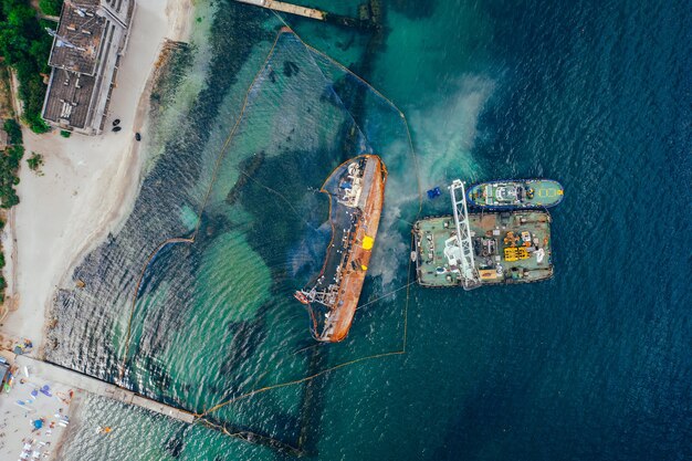 Vista dall'alto di una vecchia petroliera incagliata e ribaltata sulla riva vicino alla costa