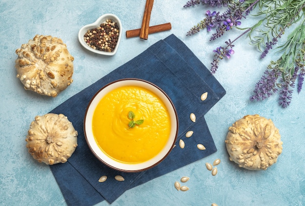 Vista dall'alto di una zuppa di crema di zucca circondata da zucche