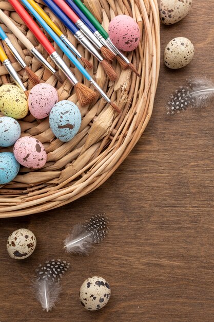 Vista dall'alto di uova colorate per pasqua con copia spazio e piume