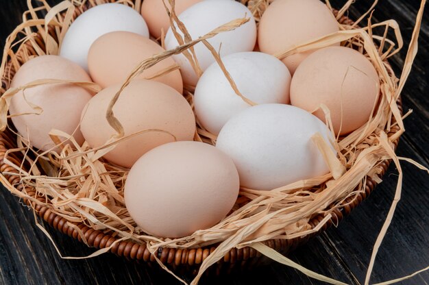 Vista dall'alto di uova di gallina sul nido su uno sfondo di legno