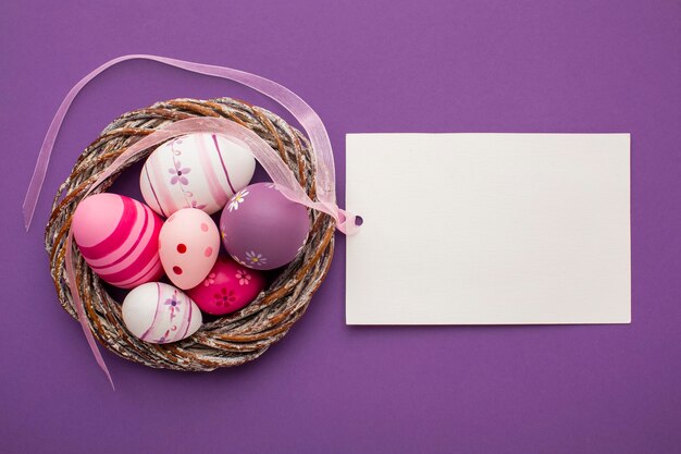 Vista dall'alto di uova di Pasqua colorate con cestino e carta