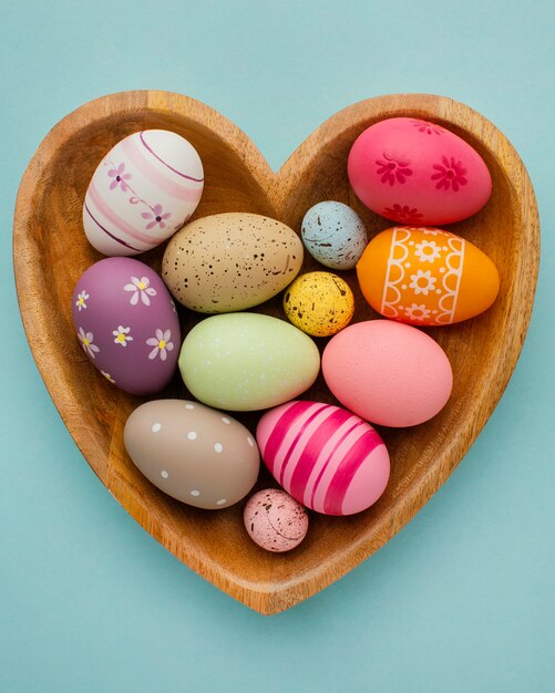 Vista dall'alto di uova di Pasqua colorate nel piatto a forma di cuore