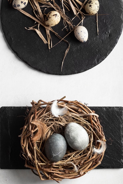 Vista dall'alto di uova di Pasqua con nido e ardesia
