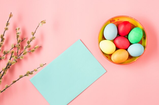 Vista dall'alto di uova di Pasqua e cartolina d'auguri in bianco