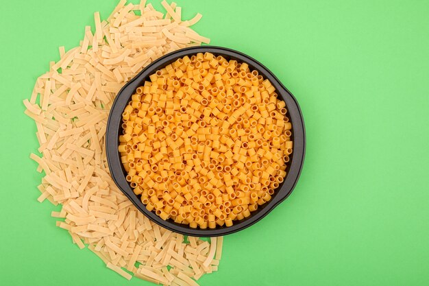 vista dall'alto di varie forme di pasta sulla superficie verde