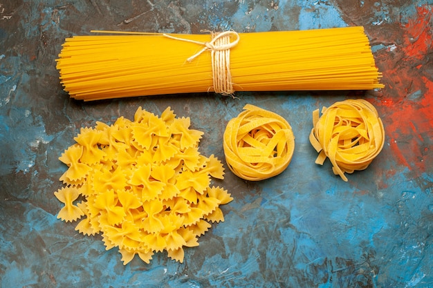 Vista dall'alto di varie paste italiane per la preparazione della cena su sfondo blu