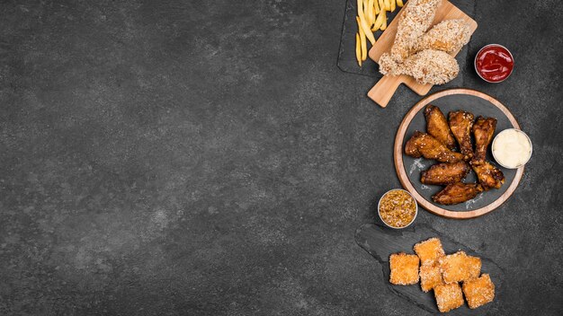 Vista dall'alto di varietà di pollo fritto con patatine fritte e spazio di copia