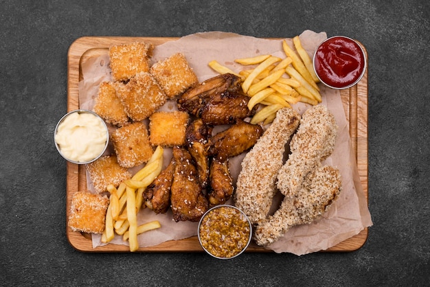 Vista dall'alto di varietà di pollo fritto con salse e patatine fritte