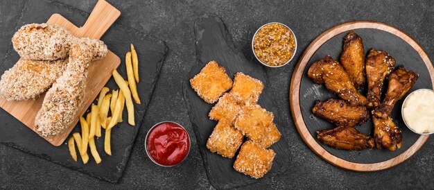 Vista dall'alto di varietà di pollo fritto con salse e patatine fritte