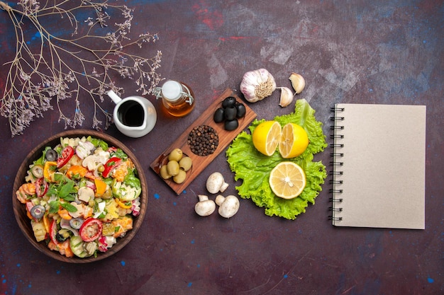 Vista dall'alto di verdura fresca. insalata con fettine di limone su nero