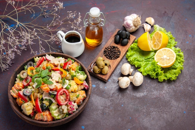 Vista dall'alto di verdura fresca. insalata con olive e fette di limone sul pavimento nero insalata alimentare dieta snack salute