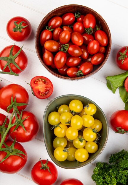 Vista dall'alto di verdure come spinaci di pomodoro coriandolo con ciotole di pomodori su legno