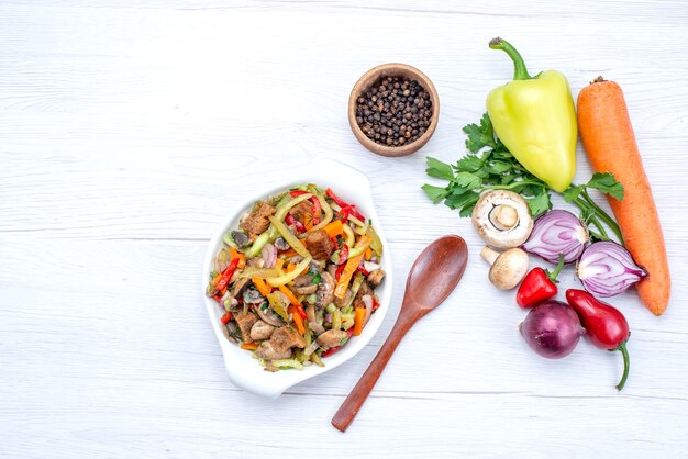 Vista dall'alto di verdure fresche come le verdure di cipolle carote e peperone verde con fette di carne su vitamina pasto leggero e vegetale