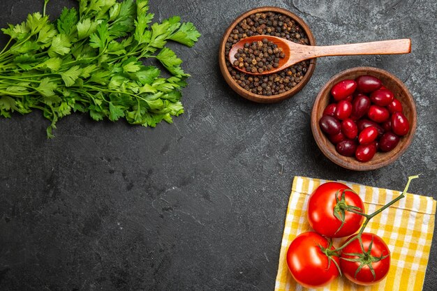 Vista dall'alto di verdure fresche con cornioli e pomodori sulla superficie grigia