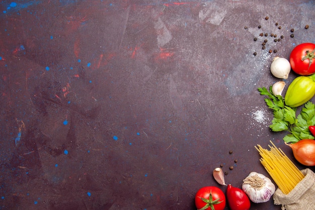 Vista dall'alto di verdure fresche con pasta cruda su nero