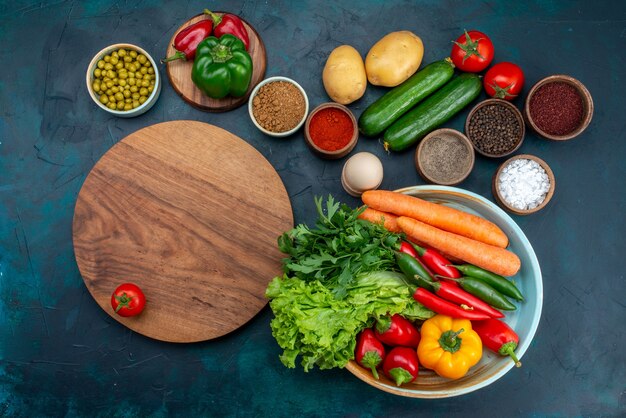 Vista dall'alto di verdure fresche con verdure e condimenti sulla scrivania blu spuntino pranzo insalata di verdure cibo