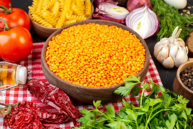 Vista dall'alto di verdure fresche fette di pane lenticchie rosse in una ciotola marrone pasta al pepe