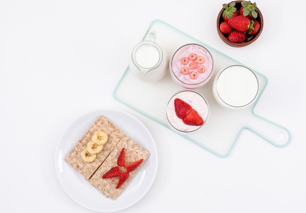 Vista dall'alto di yogurt con toast su superficie bianca orizzontale