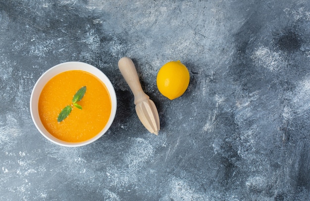 Vista dall'alto di zuppa di pomodoro e limone fresco con spremiagrumi.