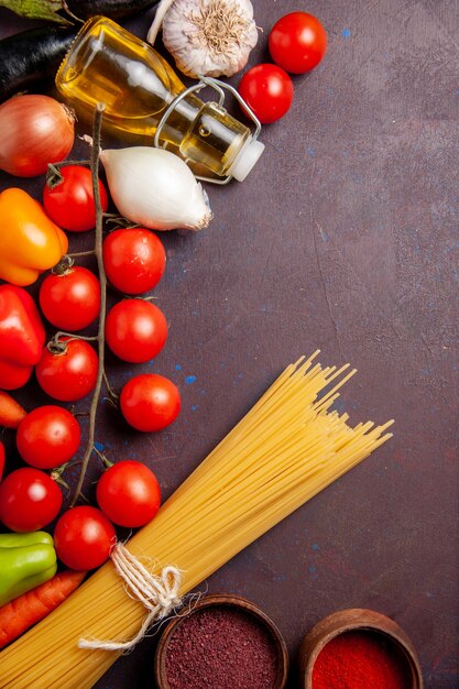 Vista dall'alto diverse verdure fresche con pasta italiana su uno spazio buio