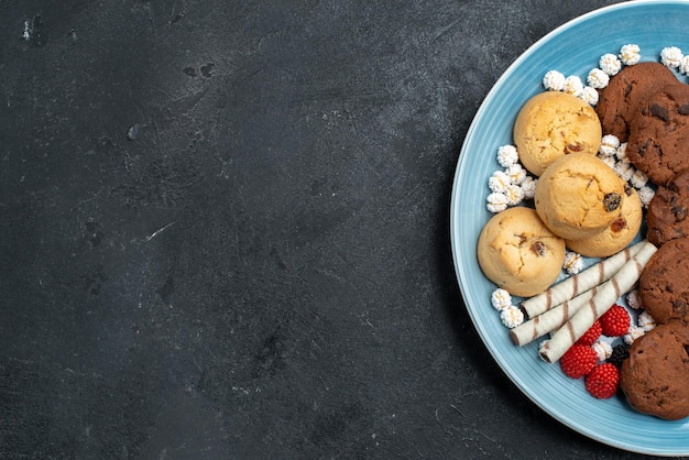 Vista dall'alto diversi biscotti dolci all'interno su superficie grigia