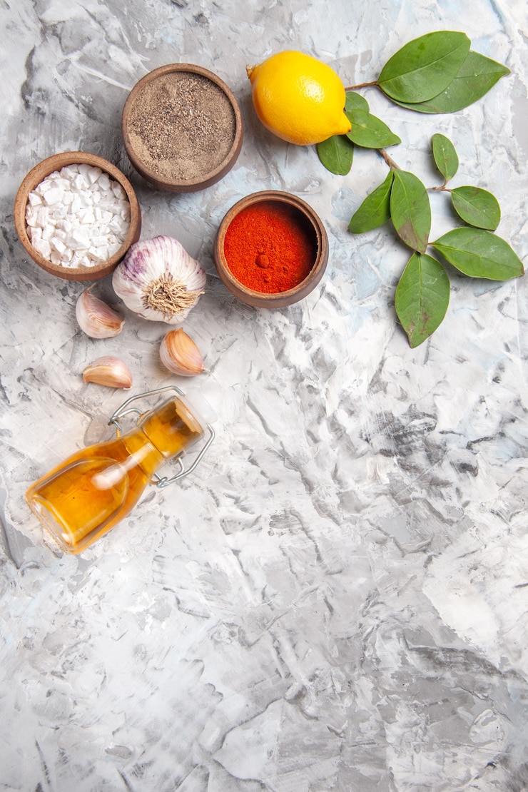 Foto gratuito vista dall'alto diversi condimenti con limone su tavola bianca olio piccante di pepe di frutta