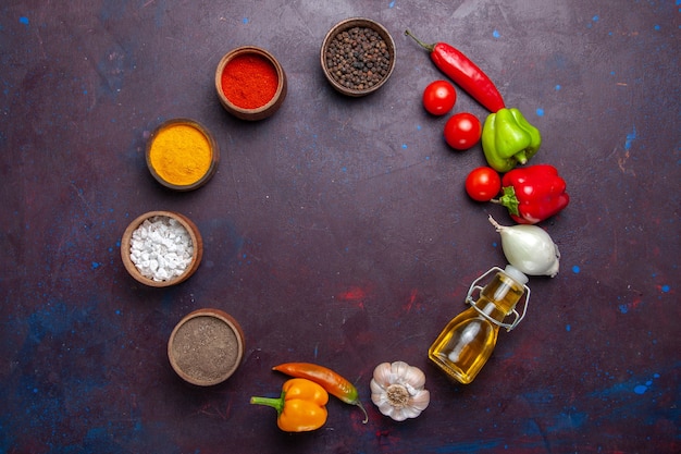 Vista dall'alto diversi condimenti con olio e verdure su sfondo scuro pasto cibo piccante vegetale