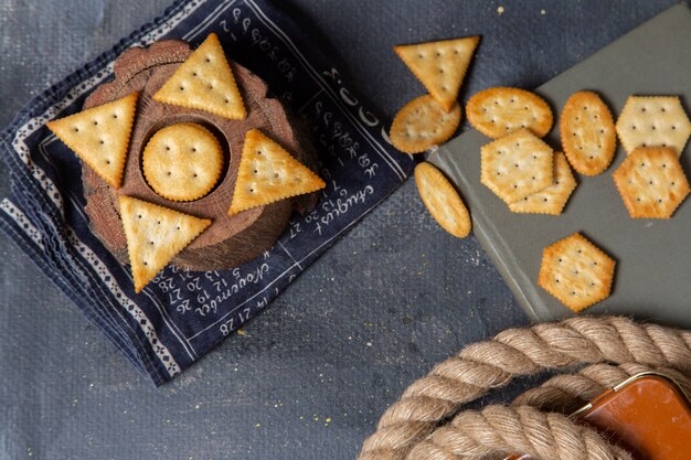 Vista dall'alto diversi cracker salati allineati su tutto lo sfondo grigio cracker croccante snack foto