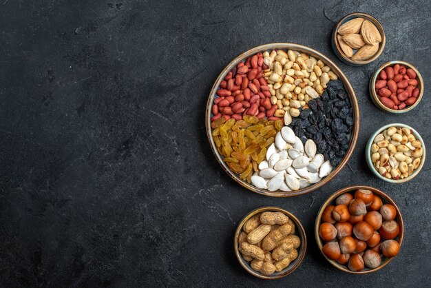 Vista dall'alto diversi dadi con uvetta e frutta secca su scrivania grigia dado spuntino uva passa frutta secca noci