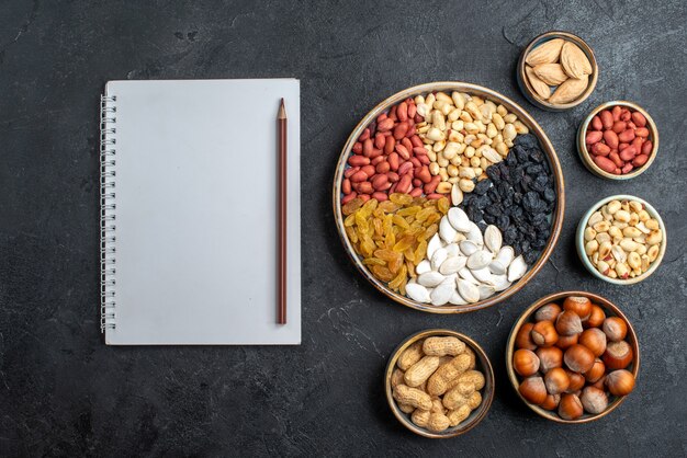 Vista dall'alto diversi dadi con uvetta e frutta secca su sfondo grigio dado spuntino uva passa frutta secca noci