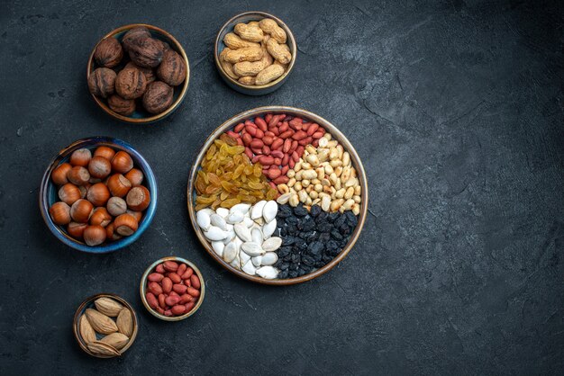 Vista dall'alto diversi dadi con uvetta e frutta secca su sfondo grigio scuro noci snack nocciole noci arachidi