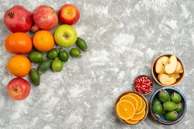 Vista dall'alto diversi frutti arance feijoa mandarini e mele su sfondo bianco mellow frutta fresca matura