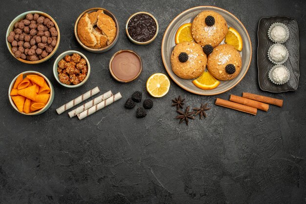 Vista dall'alto diversi snack cips biscotti fiocchi e noci sulla superficie grigia pasto snack colazione colore