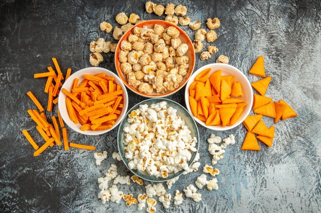 Vista dall'alto diversi snack per l'ora del film su una superficie chiara-scura