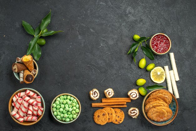 Vista dall'alto dolci biscotti dolci colorati cialde cannella agrumi con foglie