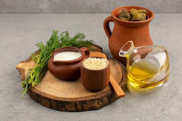 vista dall'alto dolma con carne macinata all'interno insieme a yogurt e olio d'oliva sul pavimento grigio